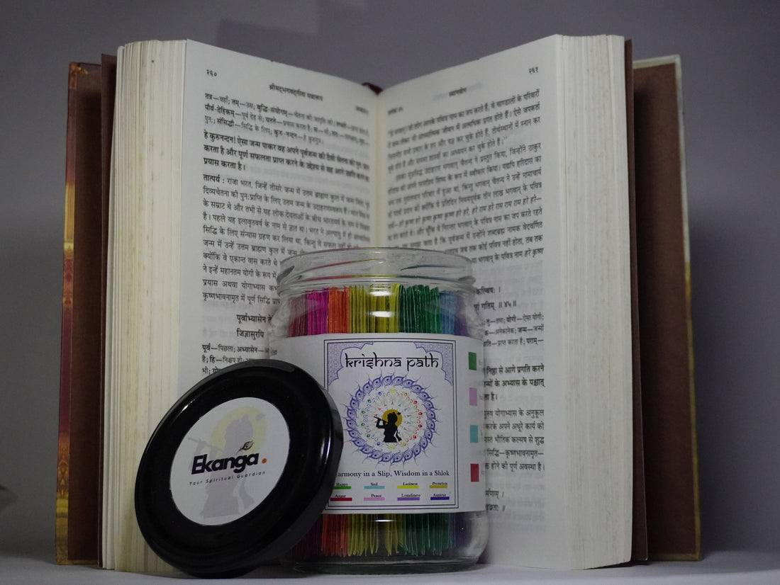 Ekanga Krishnapath Gita Jar placed in front of an open Bhagavad Gita book, showing the colorful Gita jar slips and black Ekanga lid, presented as an emotional wellness gift and Bhagavad Gita jar for peace
